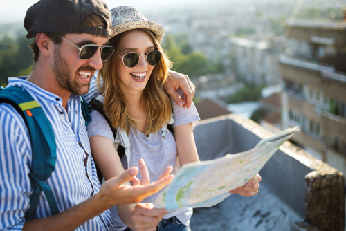 Happy,Couple,On,Vacation,Sightseeing,City,With,Map