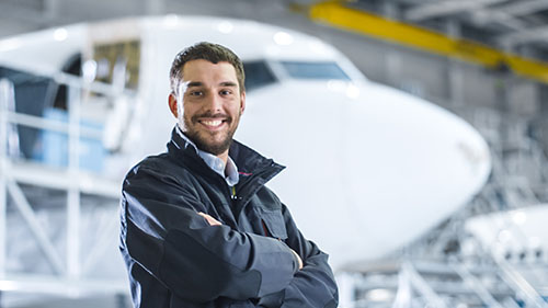 Portrait,Of,Aircraft,Maintenance,Mechanic,In,Hangar.,Airplane,On,Background.